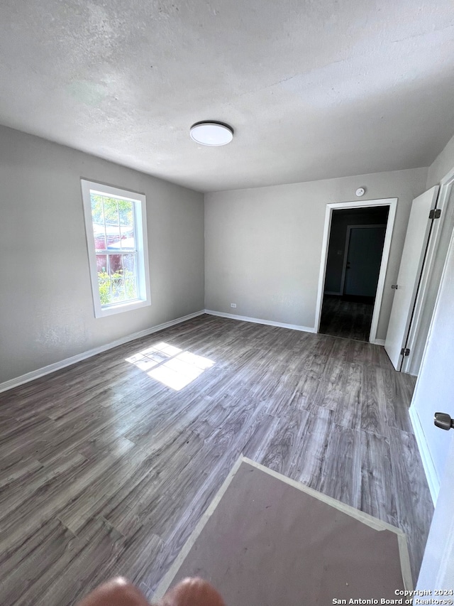 unfurnished bedroom featuring a textured ceiling and hardwood / wood-style flooring