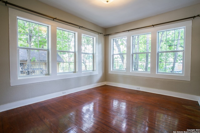 unfurnished room with hardwood / wood-style floors and a healthy amount of sunlight