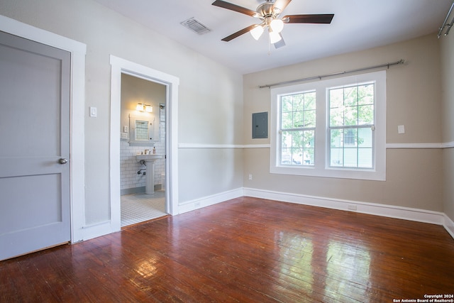 spare room with ceiling fan, hardwood / wood-style flooring, and electric panel