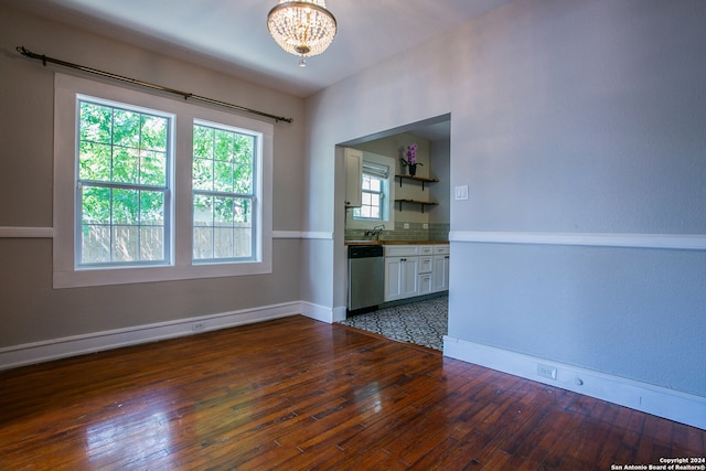 unfurnished living room with a notable chandelier, tile patterned floors, and sink