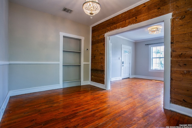 unfurnished room with a chandelier and hardwood / wood-style flooring