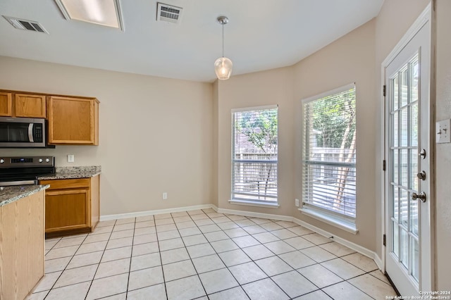 kitchen with visible vents, light stone counters, appliances with stainless steel finishes, and decorative light fixtures