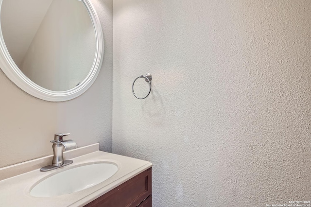 bathroom featuring a textured wall and vanity