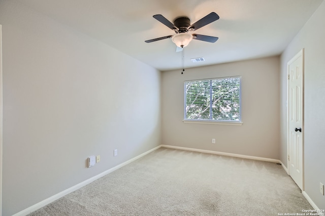 empty room with ceiling fan and light carpet