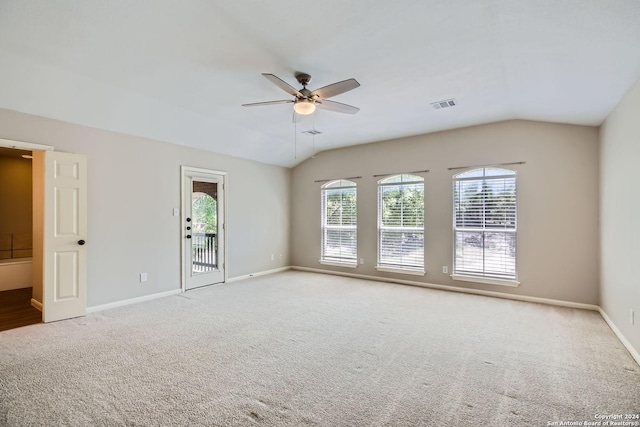 spare room with a ceiling fan, light colored carpet, visible vents, and vaulted ceiling