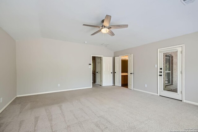 unfurnished bedroom featuring lofted ceiling, ensuite bath, carpet flooring, access to outside, and ceiling fan