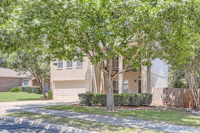 obstructed view of property featuring a garage, brick siding, fence, and driveway