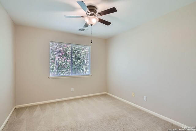 empty room with ceiling fan and light colored carpet