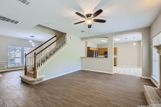 unfurnished living room featuring ceiling fan and tile patterned floors