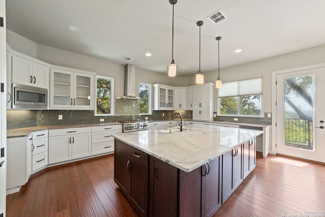 kitchen with tasteful backsplash, dark hardwood / wood-style floors, stainless steel appliances, and wall chimney exhaust hood