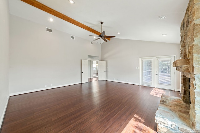 unfurnished living room with hardwood / wood-style floors, ceiling fan, beam ceiling, a stone fireplace, and high vaulted ceiling