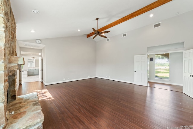 unfurnished living room with ceiling fan, beam ceiling, a stone fireplace, hardwood / wood-style flooring, and high vaulted ceiling