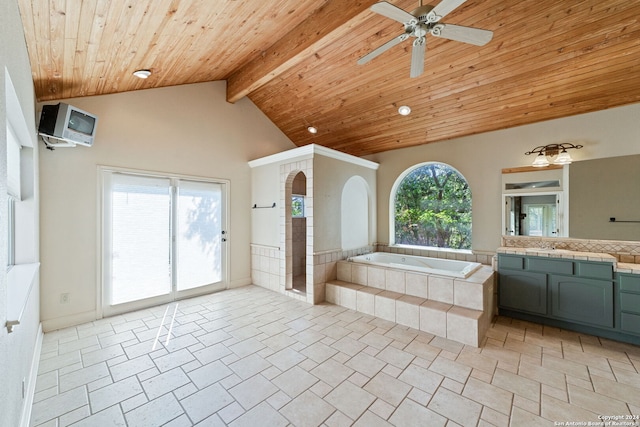 bathroom featuring tiled bath, plenty of natural light, vanity, and tile patterned flooring