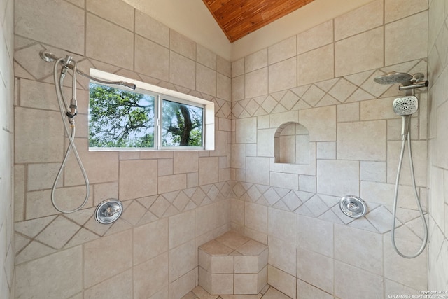 bathroom with lofted ceiling, a tile shower, and wooden ceiling