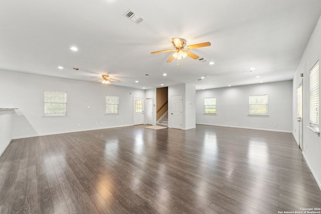 unfurnished living room with ceiling fan, dark hardwood / wood-style flooring, and a healthy amount of sunlight