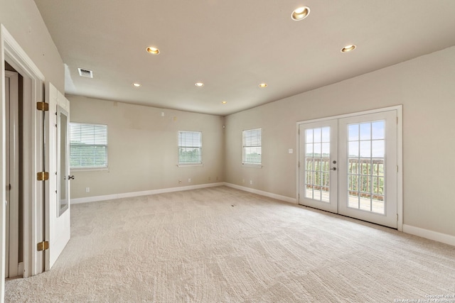 empty room featuring french doors and light colored carpet