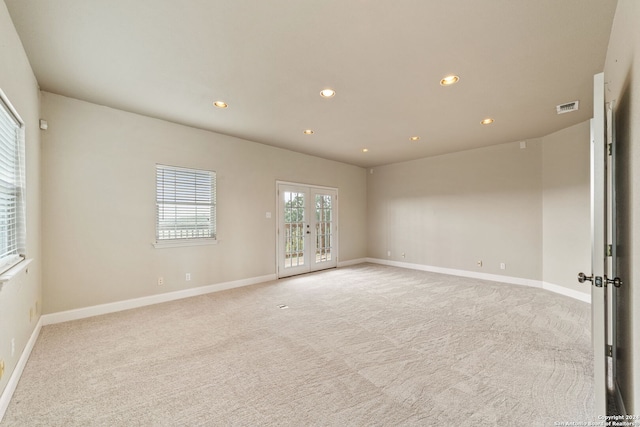 carpeted spare room with french doors