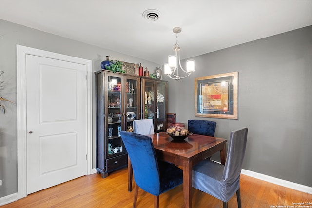 dining area featuring light hardwood / wood-style flooring and a chandelier