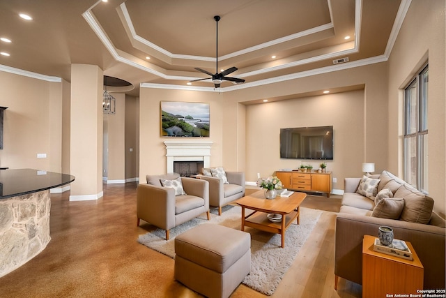 living room featuring crown molding, ceiling fan, and a tray ceiling