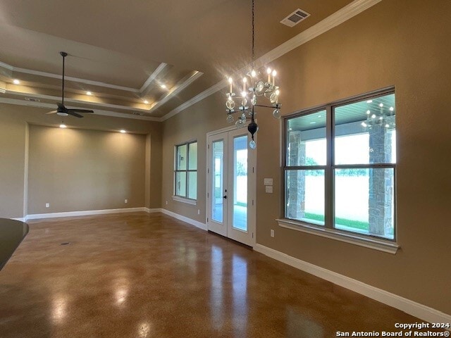 spare room featuring ceiling fan with notable chandelier, a tray ceiling, concrete floors, ornamental molding, and french doors