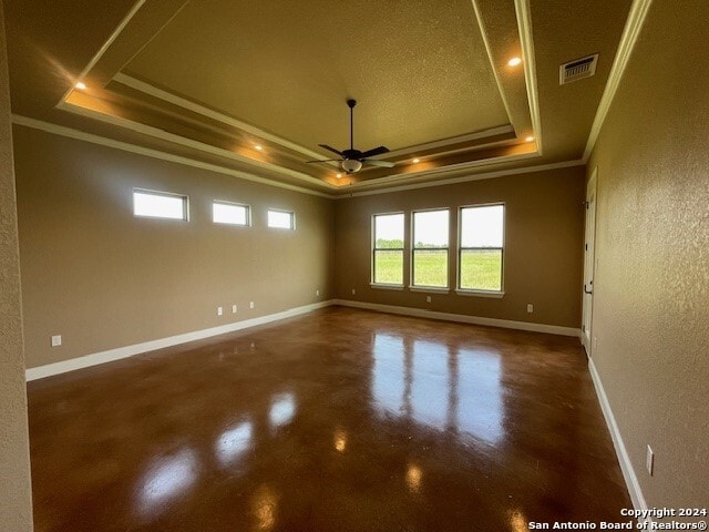 unfurnished room featuring ceiling fan, a raised ceiling, crown molding, and concrete flooring