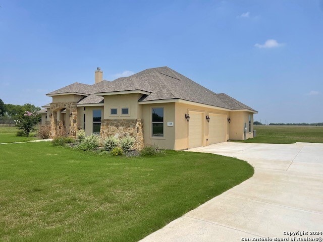 view of front of property featuring a front lawn and a garage