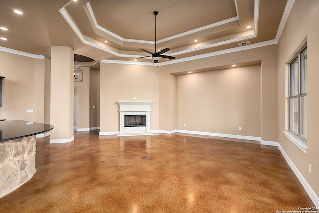 unfurnished living room with a tray ceiling, ceiling fan, ornamental molding, and a fireplace