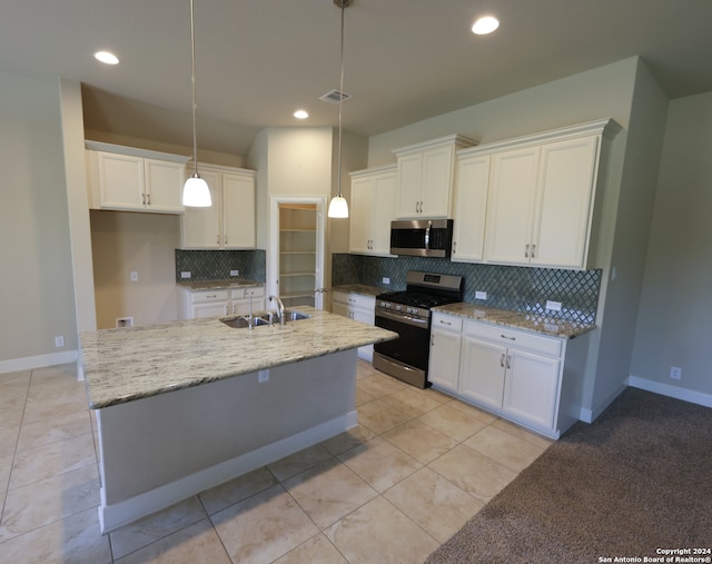 kitchen with appliances with stainless steel finishes, decorative backsplash, sink, and white cabinetry