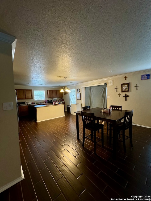 dining area featuring a textured ceiling, dark hardwood / wood-style floors, and a notable chandelier