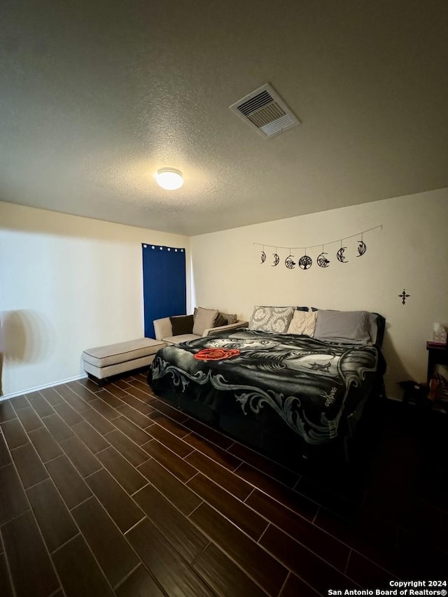 534 Gable Pt, San Antonio, TX 78251 - bedroom with baseboards, visible vents, a textured ceiling, and wood tiled floor