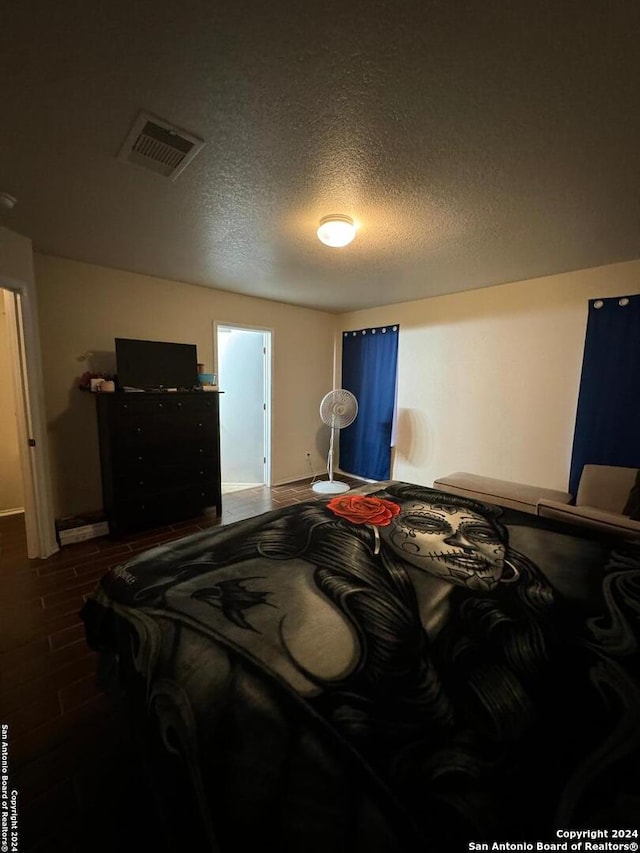 bedroom featuring wood-type flooring and a textured ceiling