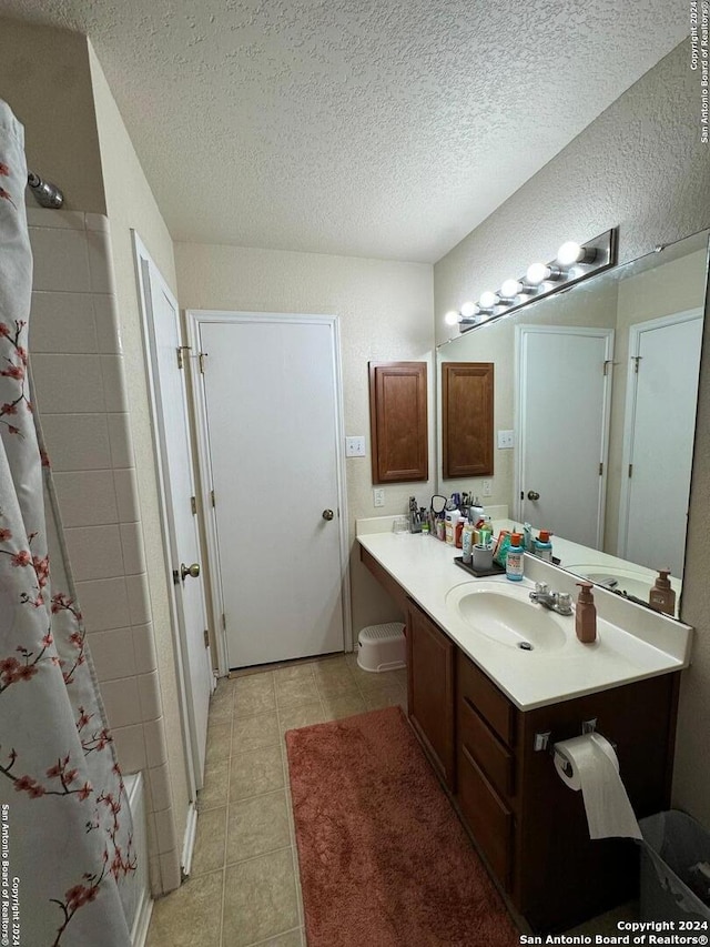 534 Gable Pt, San Antonio, TX 78251 - full bathroom featuring vanity, tile patterned flooring, a textured ceiling, and shower / bathtub combination with curtain