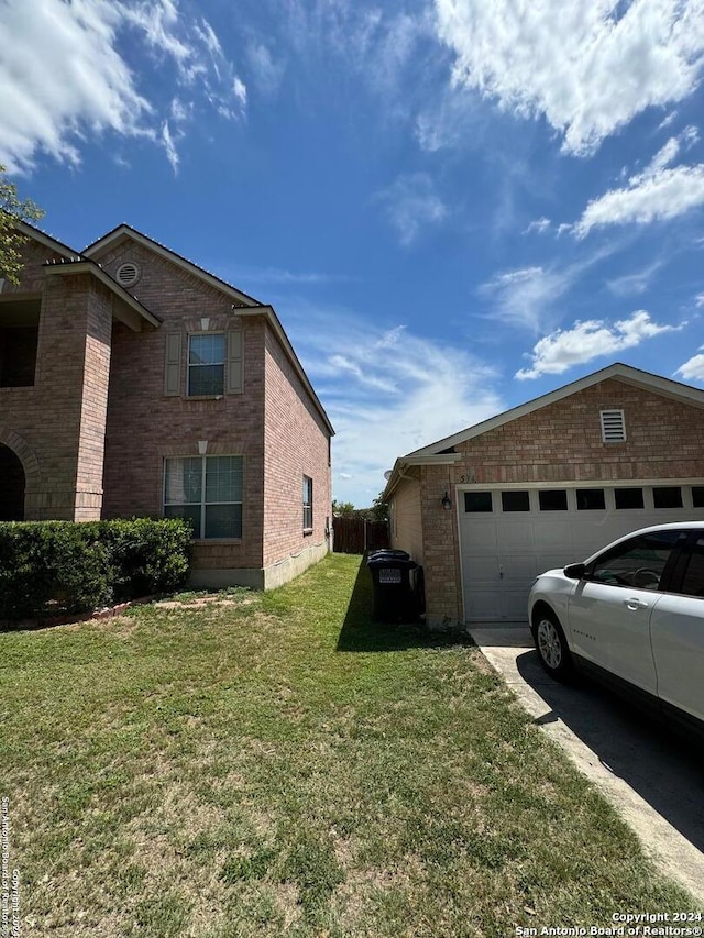 view of side of property featuring a lawn and a garage