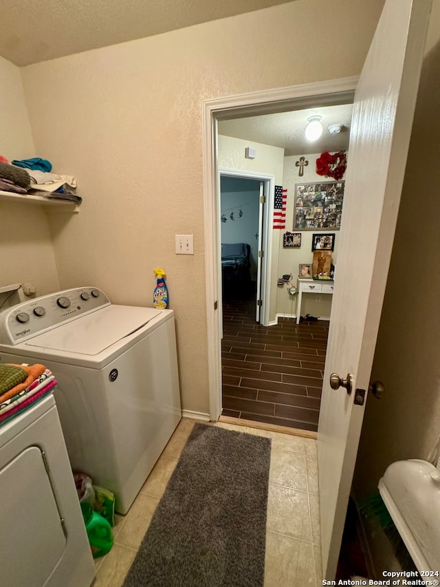 clothes washing area featuring washer and clothes dryer and tile patterned flooring