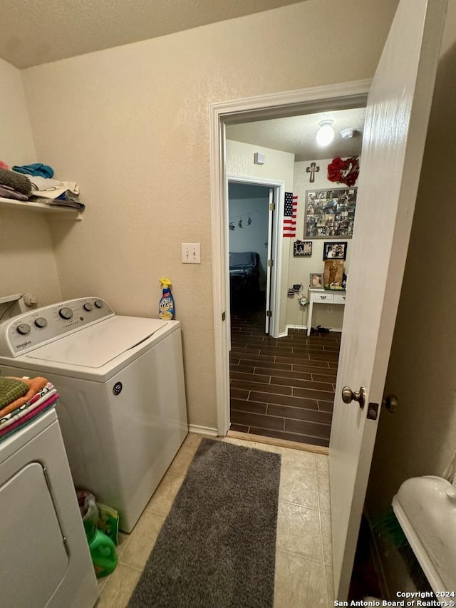 534 Gable Pt, San Antonio, TX 78251 - laundry room with a textured ceiling, washer and dryer, laundry area, and light tile patterned flooring