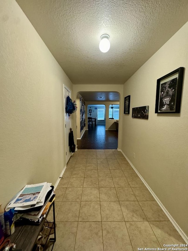 534 Gable Pt, San Antonio, TX 78251 - corridor featuring baseboards, a textured ceiling, and light tile patterned floors