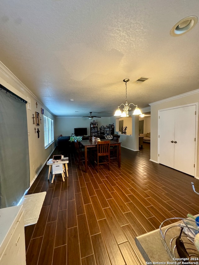 dining space with a textured ceiling, an inviting chandelier, ornamental molding, and hardwood / wood-style floors