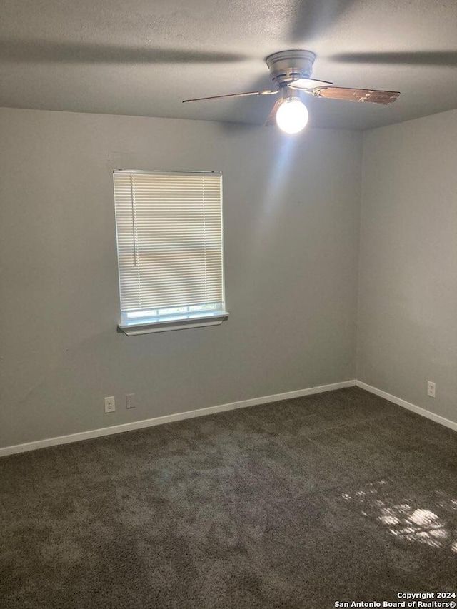empty room featuring baseboards, a textured ceiling, a ceiling fan, and carpet floors