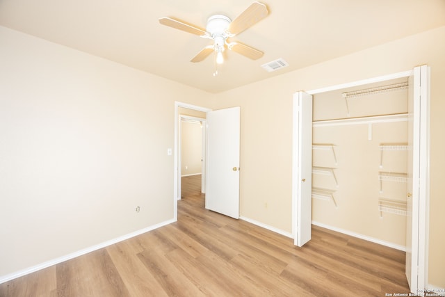 unfurnished bedroom featuring ceiling fan, light hardwood / wood-style floors, and a closet