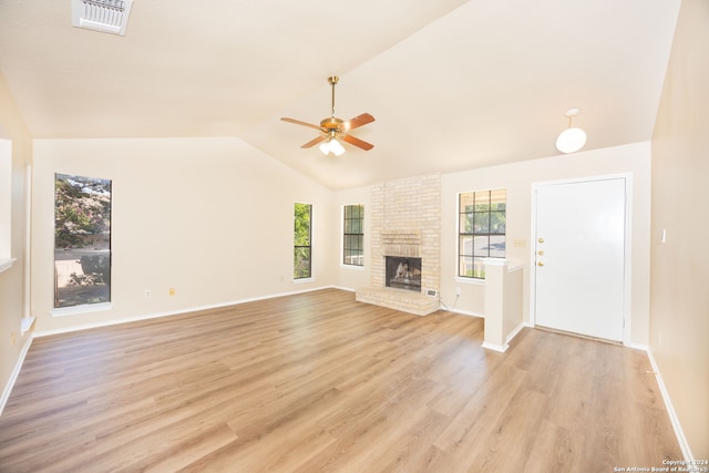 unfurnished living room with ceiling fan, light hardwood / wood-style floors, vaulted ceiling, and a brick fireplace