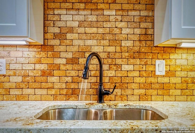 448 Melody, Uvalde, TX 78801 - kitchen view of a sink, tasteful backsplash, and light stone countertops