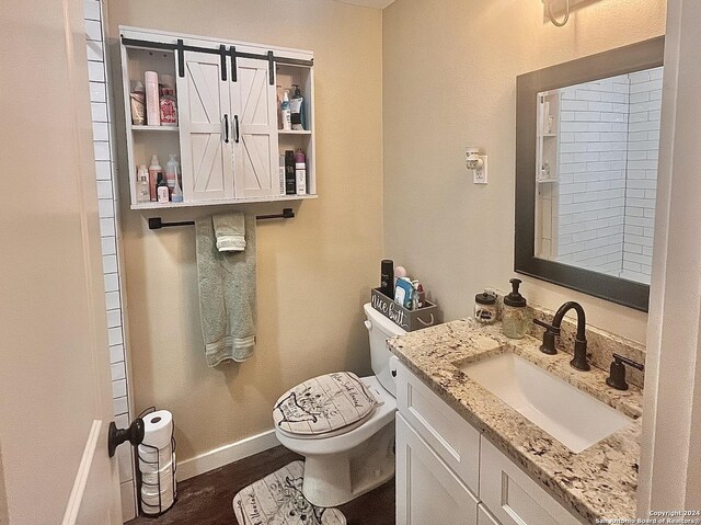 448 Melody, Uvalde, TX 78801 - half bathroom with toilet, wood finished floors, baseboards, and vanity