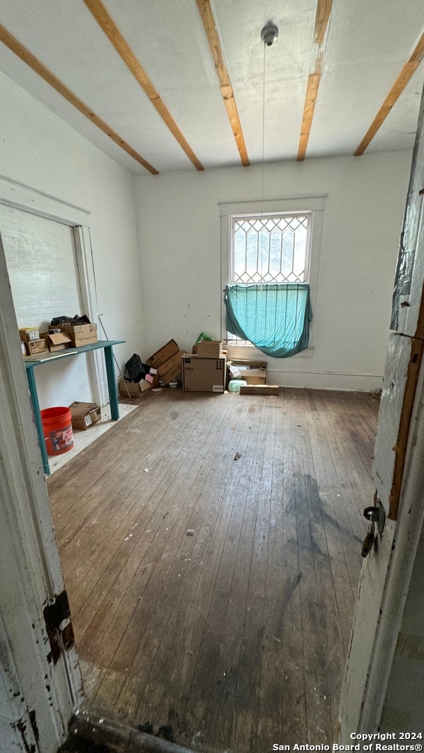 interior space featuring beamed ceiling and hardwood / wood-style floors