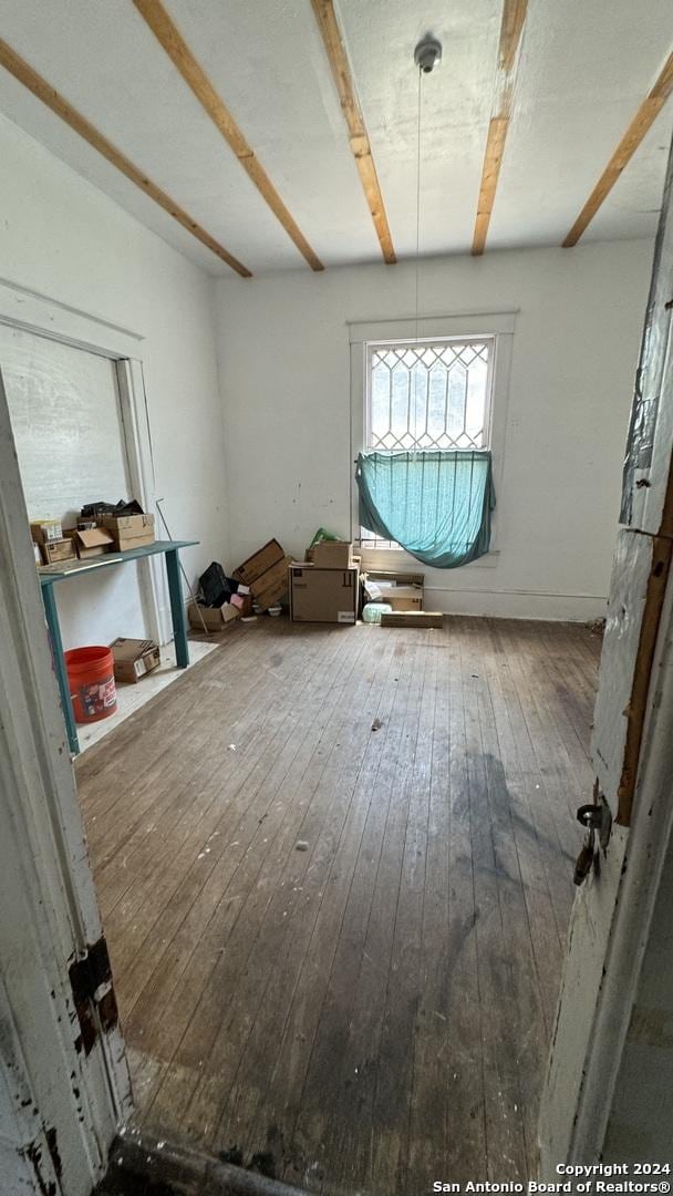 miscellaneous room featuring beamed ceiling and hardwood / wood-style floors