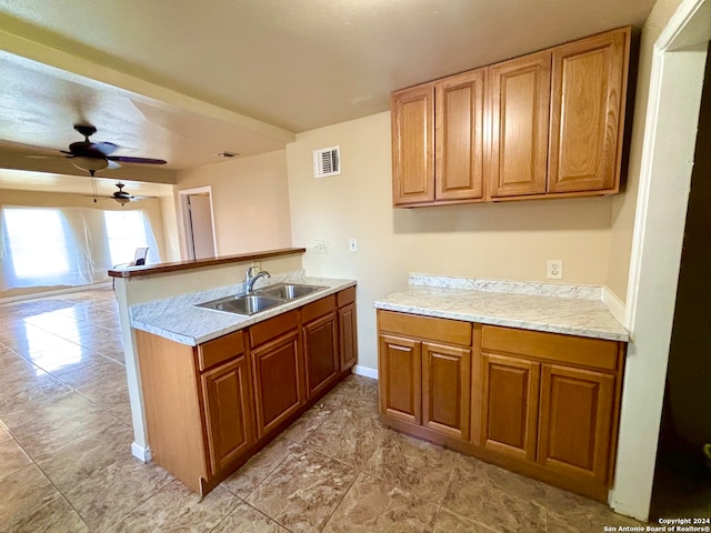 kitchen with ceiling fan, kitchen peninsula, sink, and light tile patterned floors