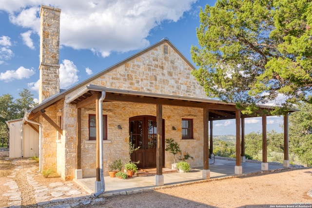 view of front of home with stone siding and a chimney