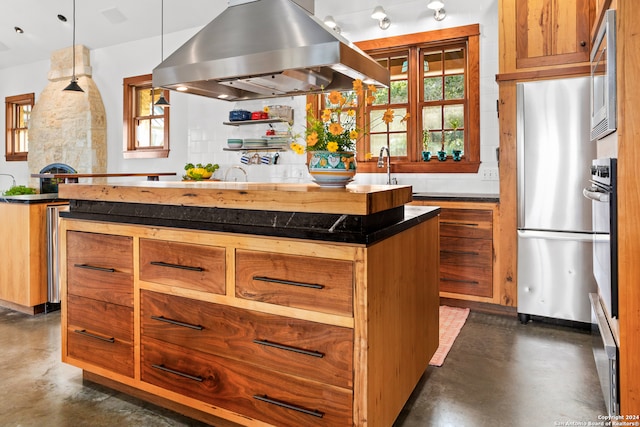 kitchen with stainless steel appliances, a center island, decorative light fixtures, island range hood, and sink