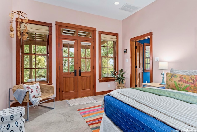 bedroom with french doors, multiple windows, visible vents, and baseboards