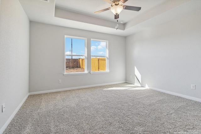 unfurnished room featuring carpet flooring, ceiling fan, and a tray ceiling