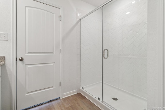 bathroom with wood-type flooring and walk in shower